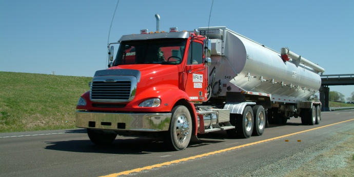 Red grain hauler drives down the highway