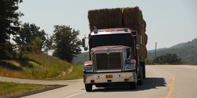 A front view of a red semi hauling bales of hay