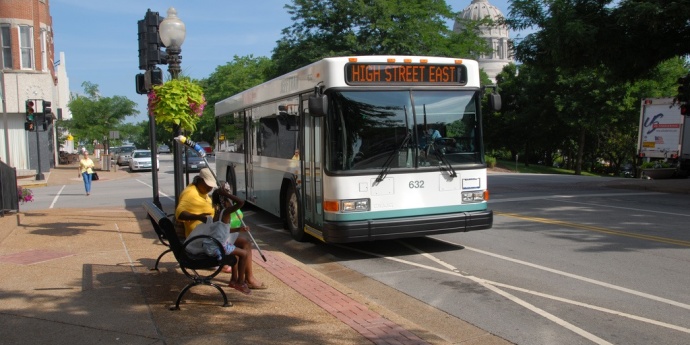 people wait to board a bus