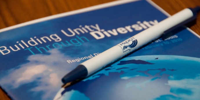 Image of a unity through diversity handbook and pen