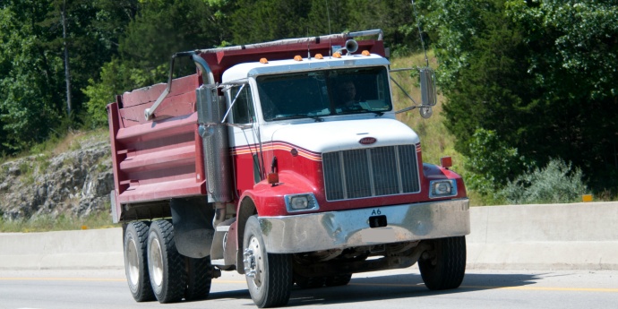 Dump truck on a rural highway driving toward the viewer