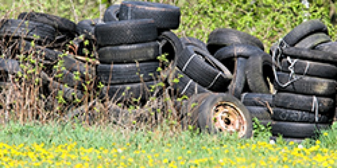 Image of used tires stacked in a field