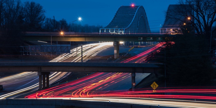 Night highway with traffic crossing bridges
