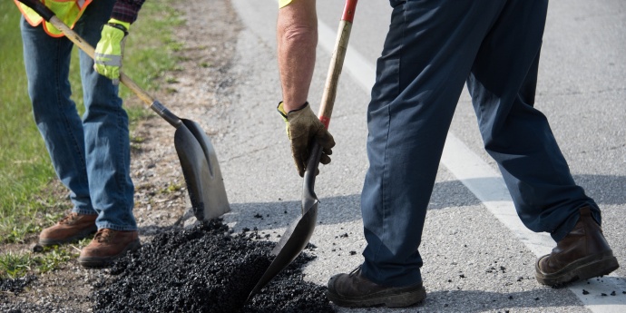 employees patch a pothole