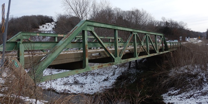 Photo from January 2024 showing the green truss structure on the side of the Cooper County Route HH Brushy Creek Bridge.