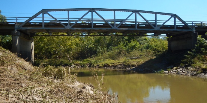 Wide angle view of the Shoal Creek bridge from creek bank