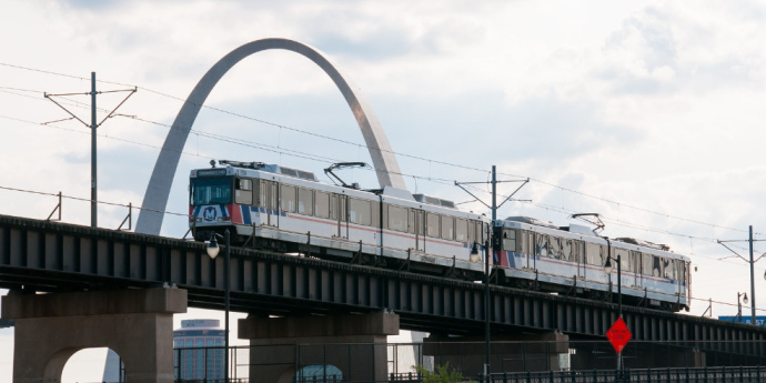 train on rail road in front of arch
