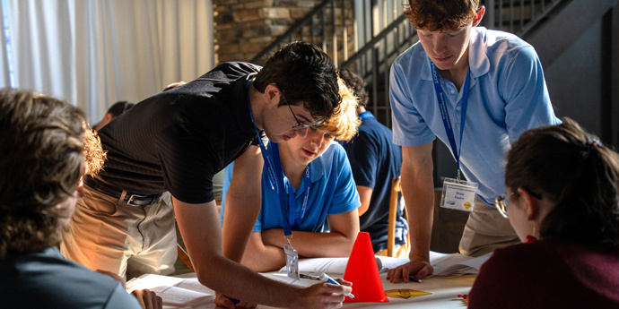 Interns gathered around a table engineering a plan