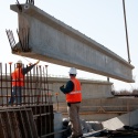 Road workers placing beam on HWY 63