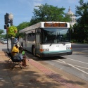 people wait to board a bus