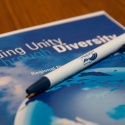 Image of a unity through diversity handbook and pen