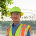 Engineer in PPE with bridge in background