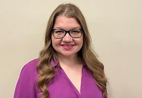 woman with blonde hair and glasses wearing purple shirt