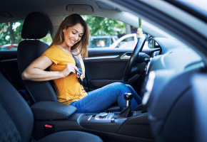 Woman fastening a seat belt in a car