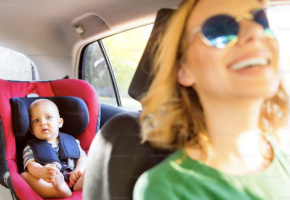 Child secured in a car seat behind a driver