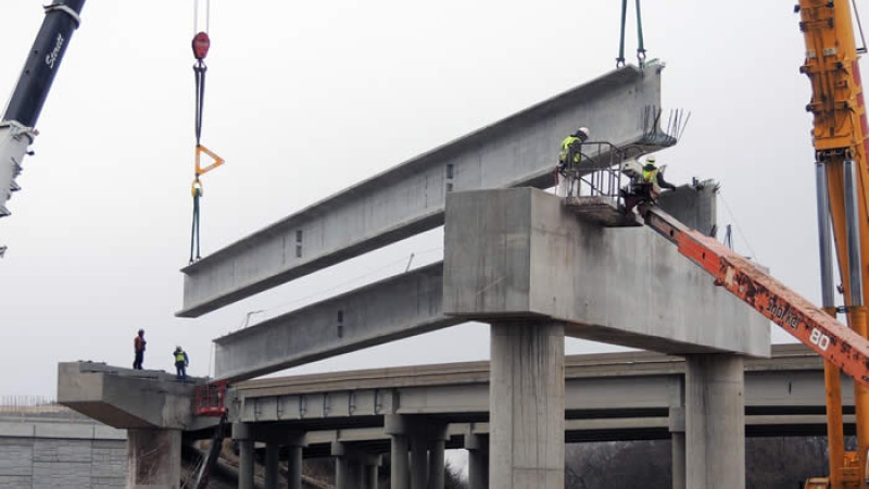 Crews lift one of the girders of the flyover ramp from 141 to I-44 into place