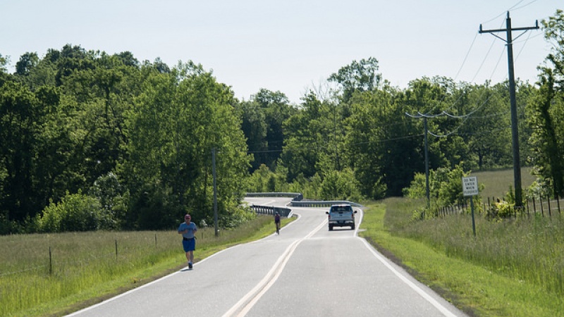 Person safely jogging along road