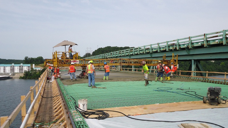Construction crew pouring concrete on bridge deck