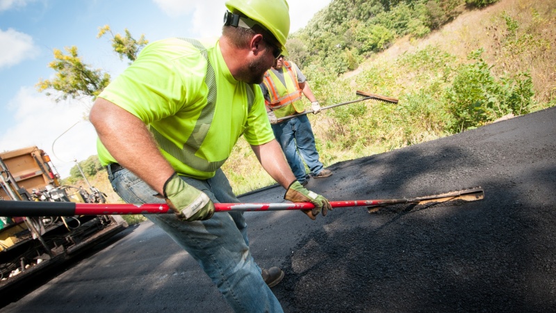 a crew spreads asphalt