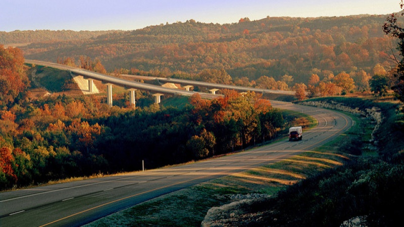 Truck driving rural highway near sunset