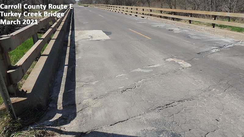 Photo showing the deterioration of the asphalt driving surface of the Carroll County Route E Turkey Creek Bridge