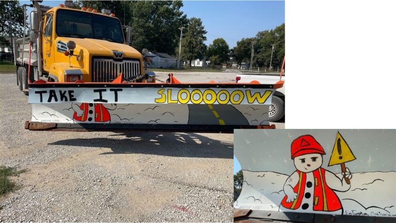 Snow plow painted with a snowman in a high-visibility vest and hard hat