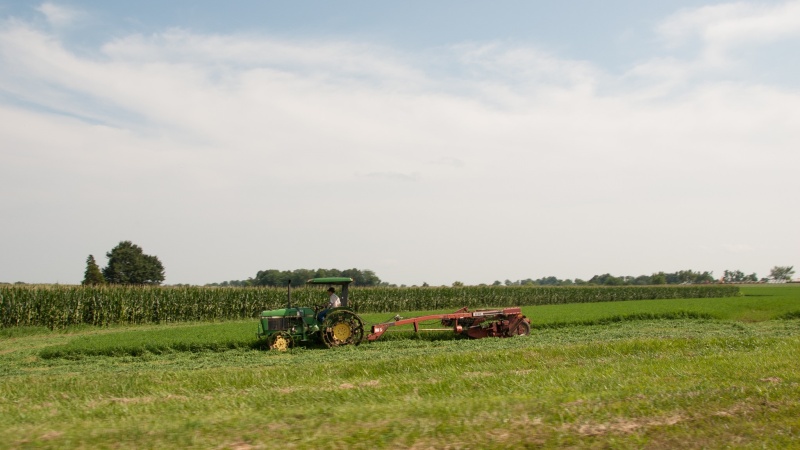 A tractor pulls equipment across a farm