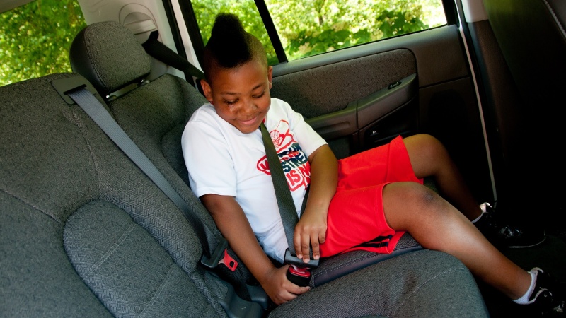kid buckling a seat belt