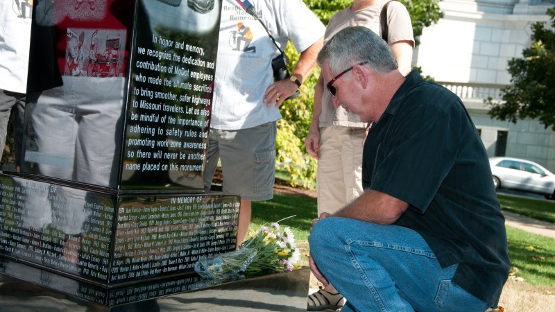 a man kneels at the memorial
